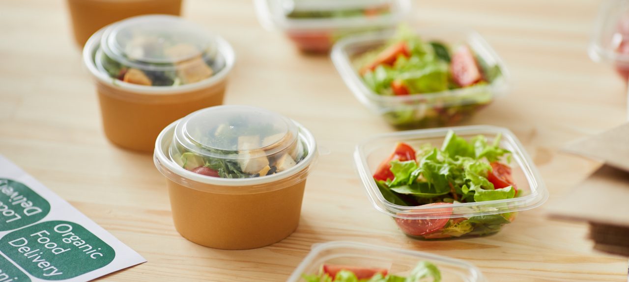 Background image of healthy food portions ready for packaging on wooden table in small food delivery service, copy space
